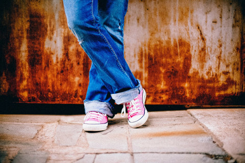 Young child's legs, wearing jeans and pink sneakers