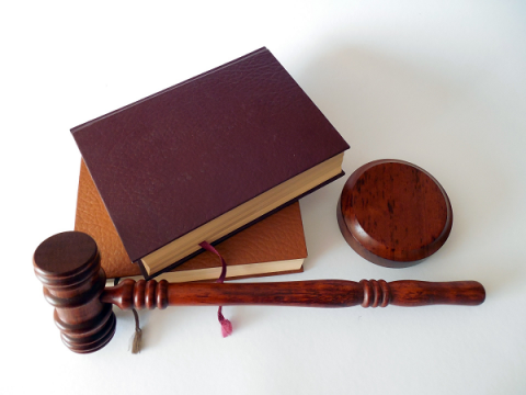 wooden gavel, two brown hardback books and a wooden block for gavel-tapping
